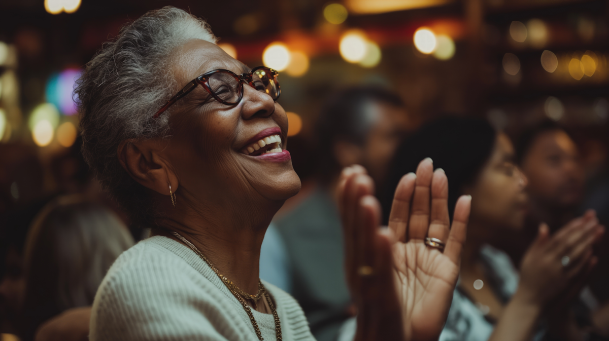 Elderly woman smiling and clapping at event, happiness and celebration